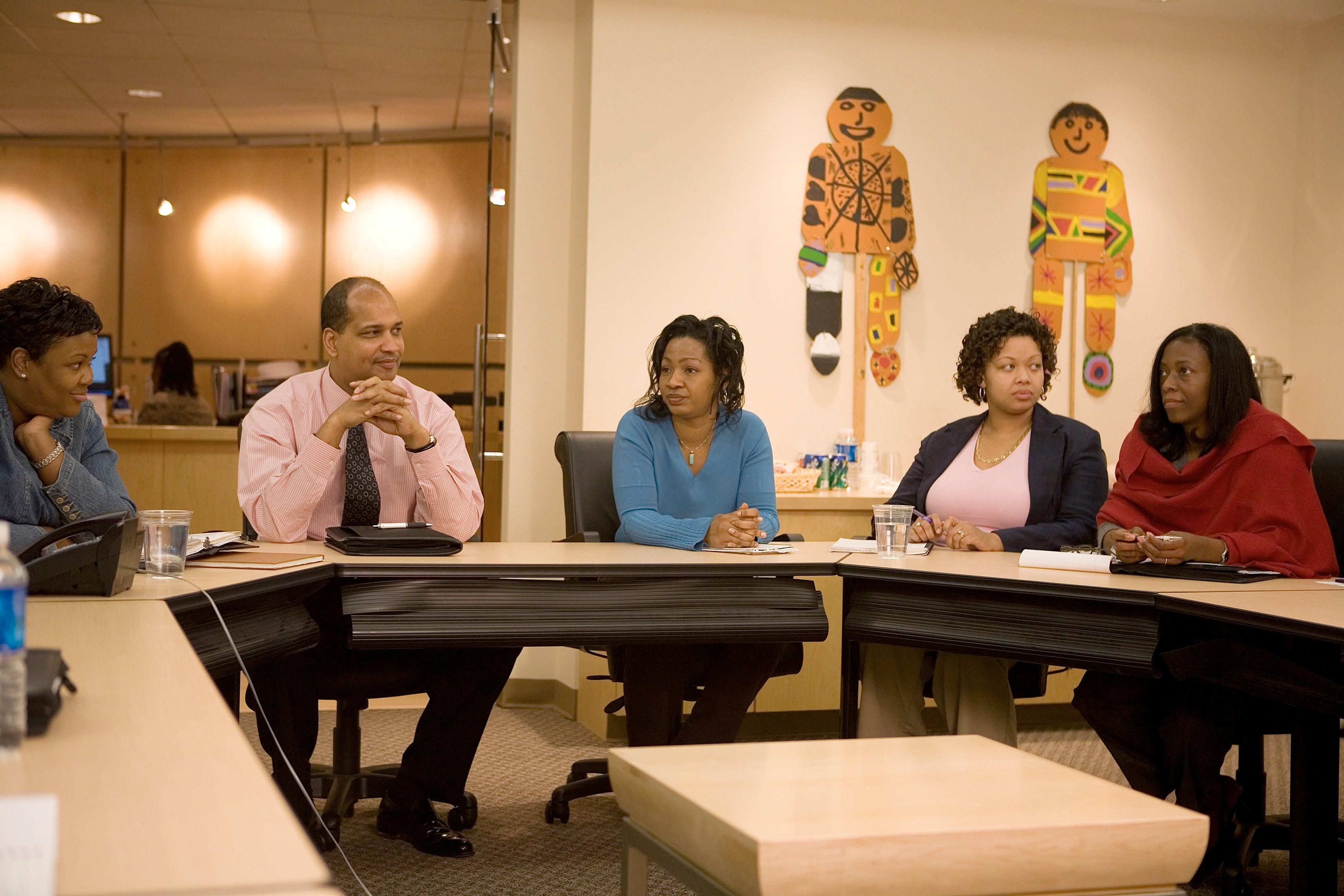 Education leaders sit around a table holding a discussion.