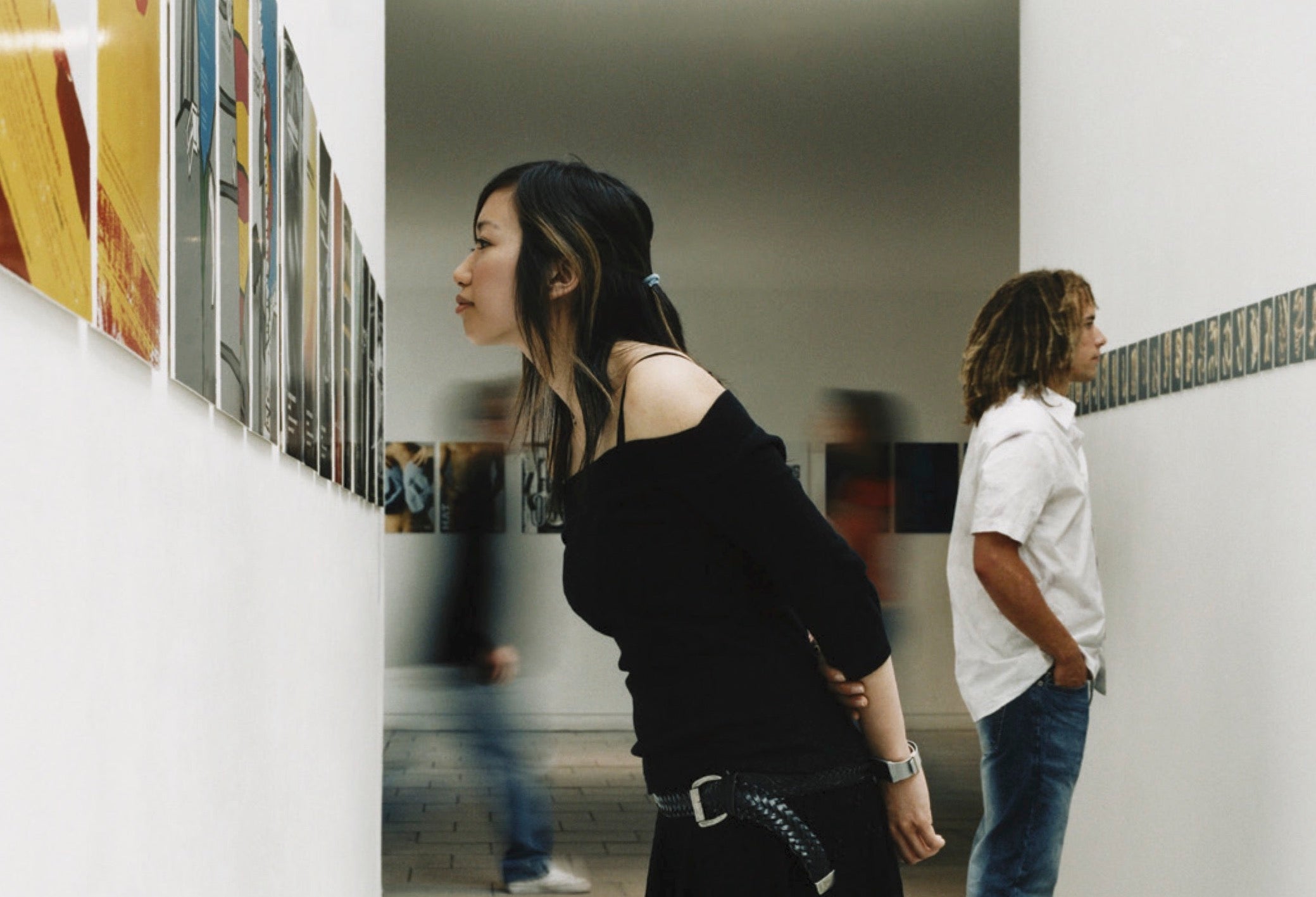 Art gallery attendees look closely at some wall art.