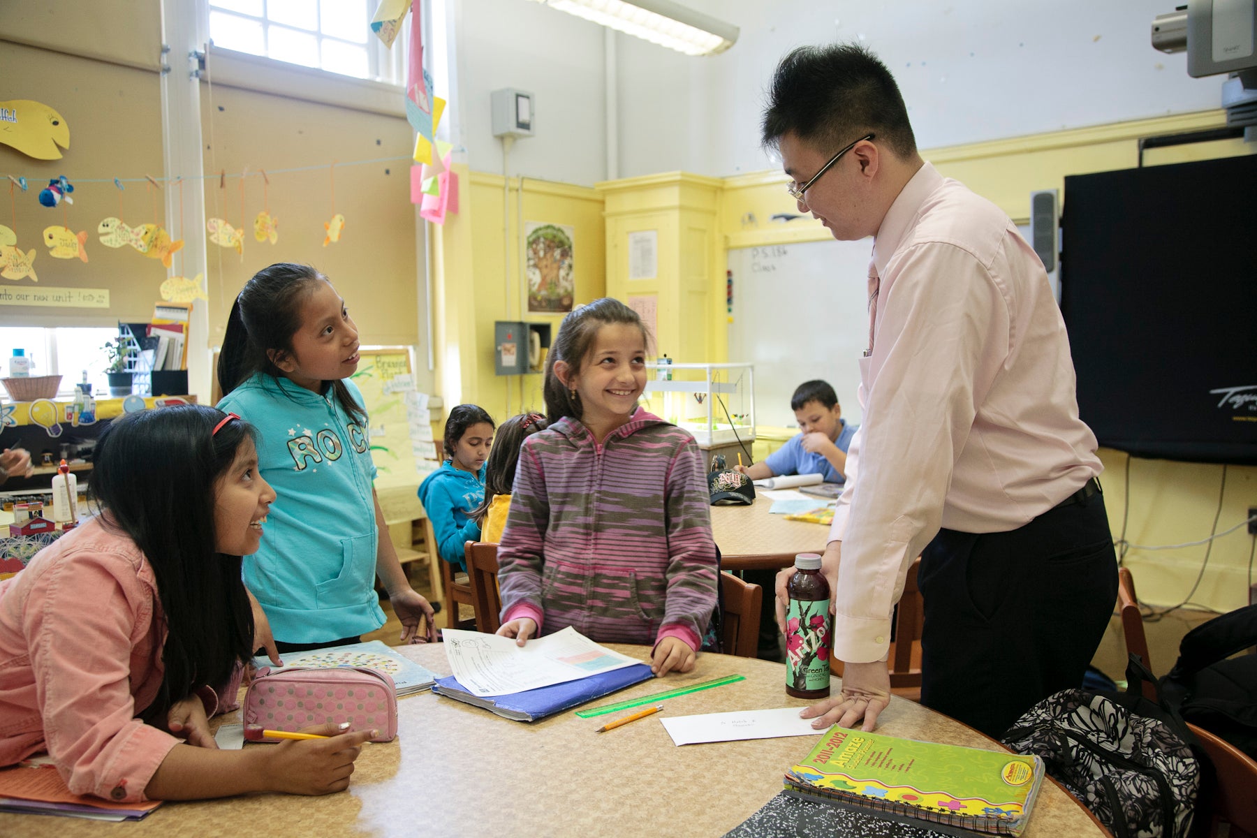 A school principal engages with students in class.