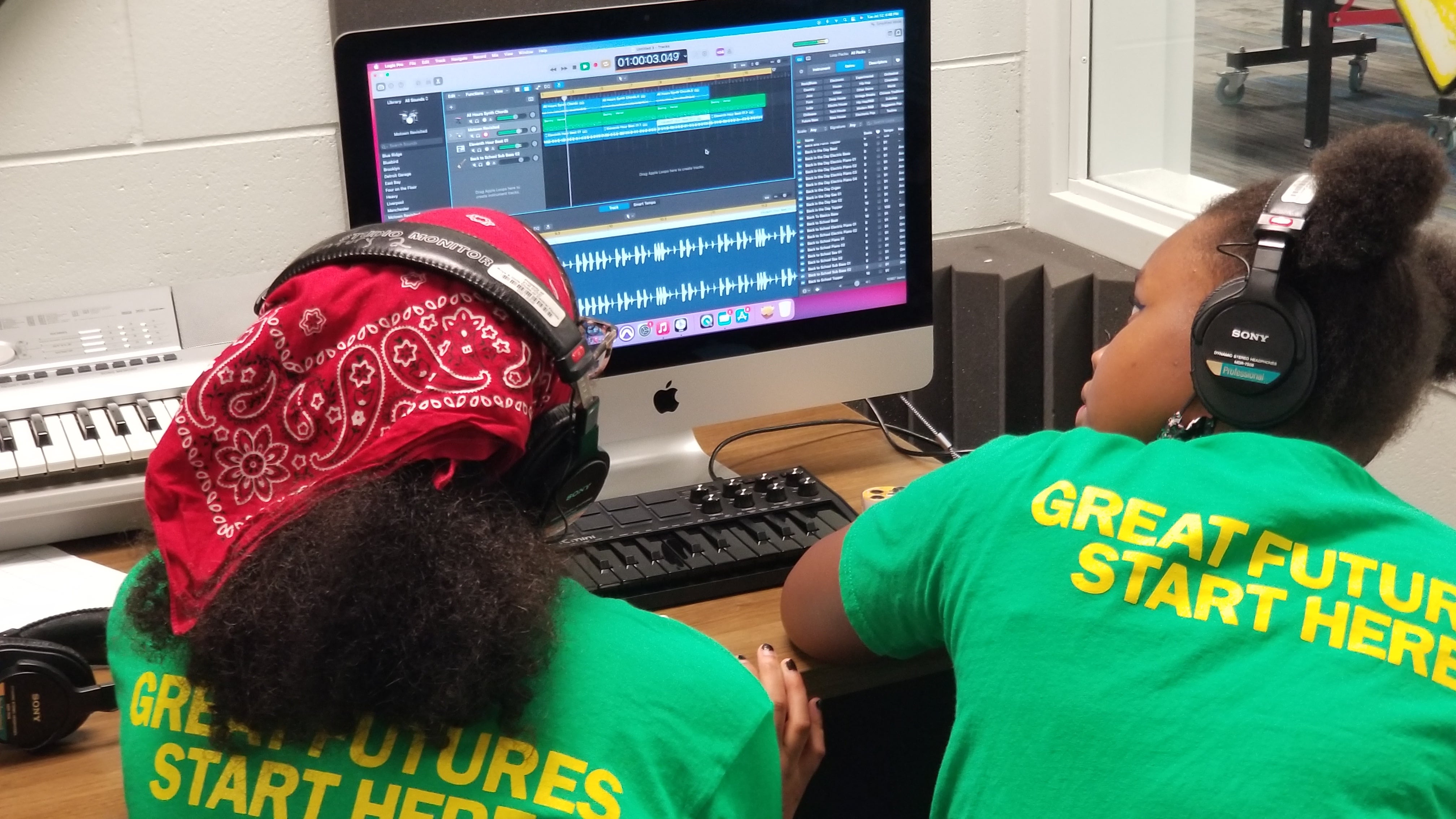 Two students in an afterschool program play around with audio editing software.