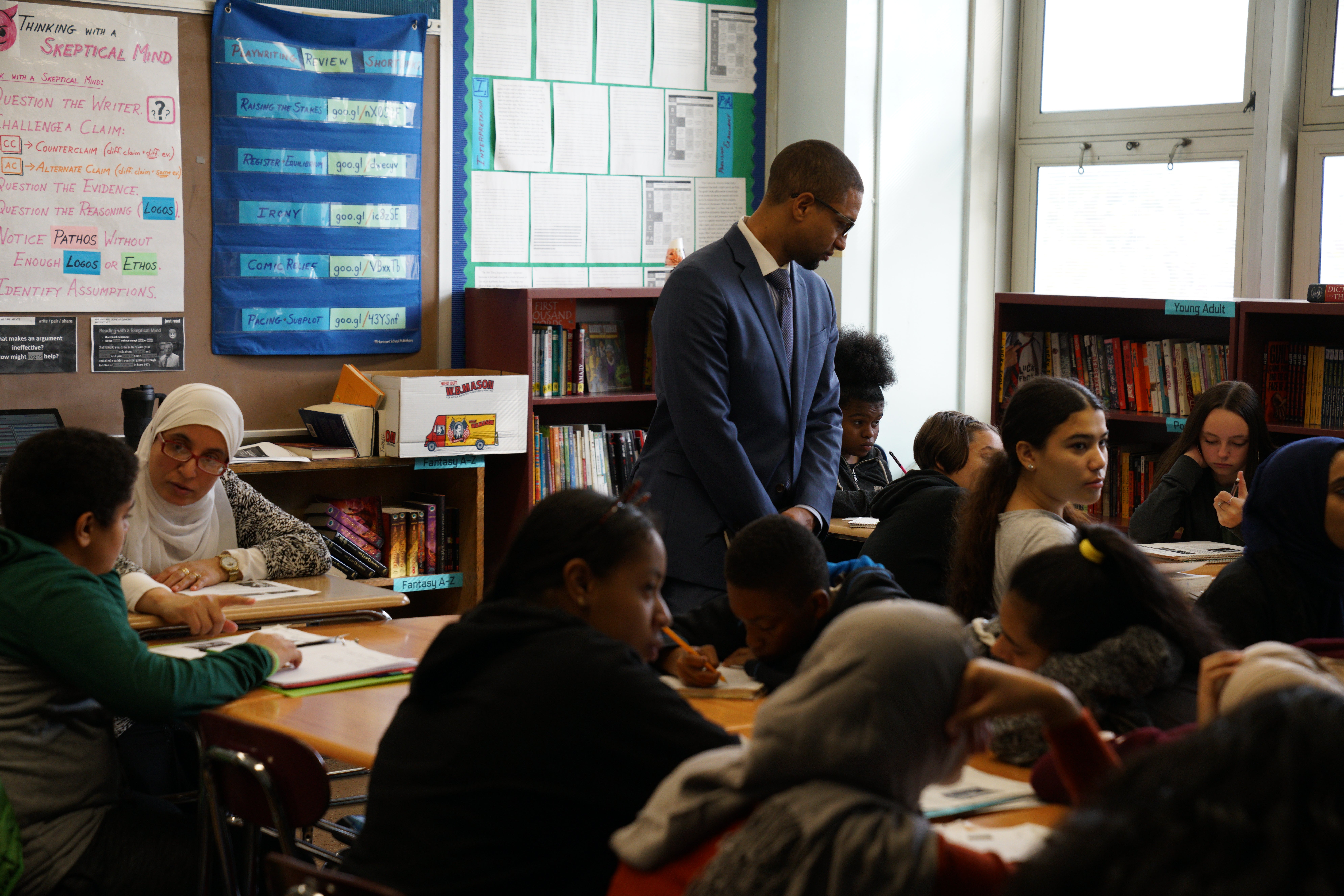 A school principal observes students in their classroom.