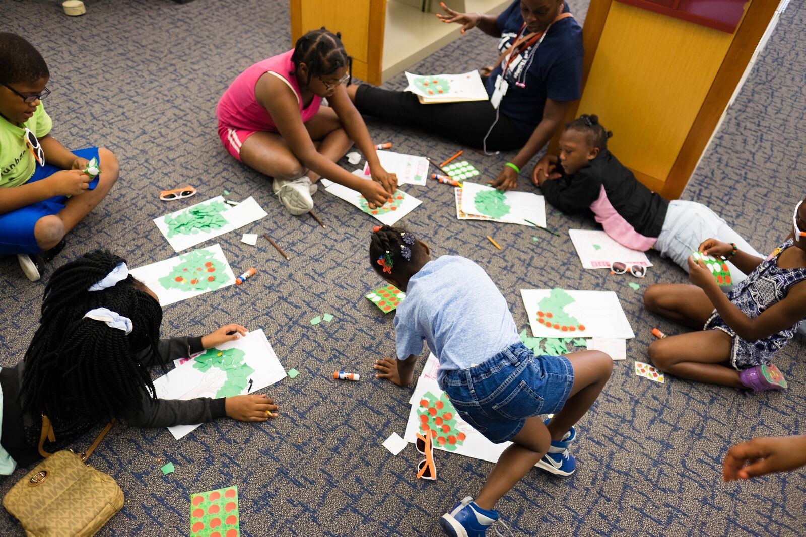 Children work on their drawings on the floor of a public library in Dallas.