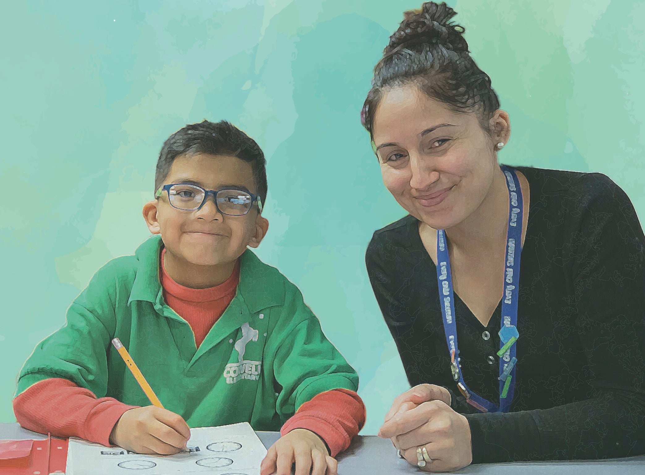 A student and his teacher smiles at the camera.