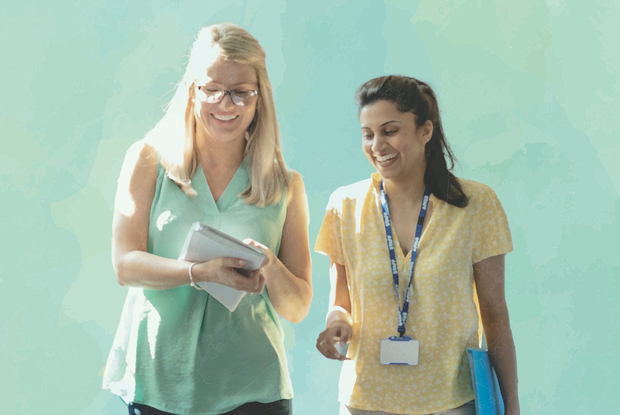 Two teachers walk alongside each other.