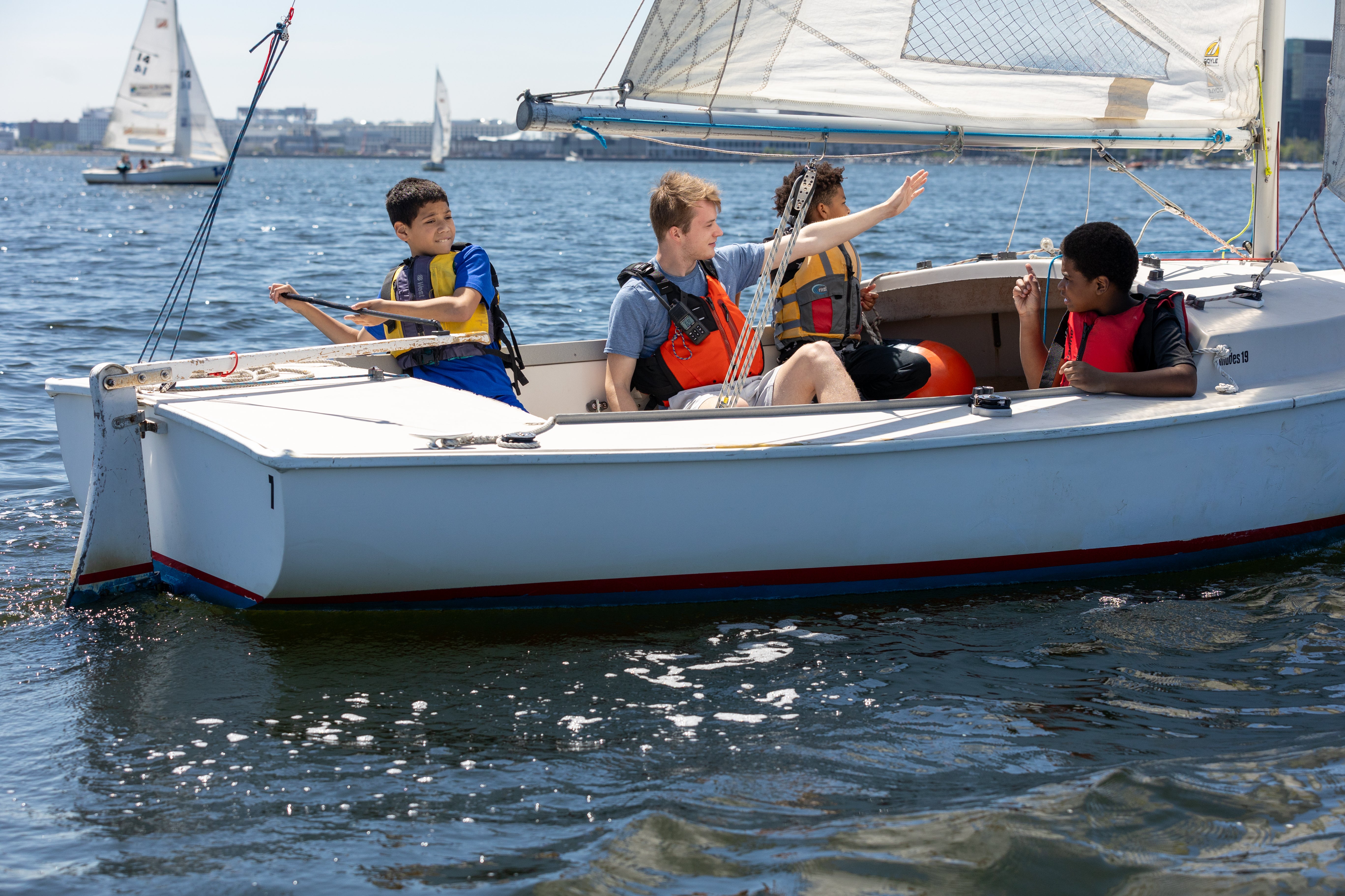 Four children on sailboat in Boston afterschool program.