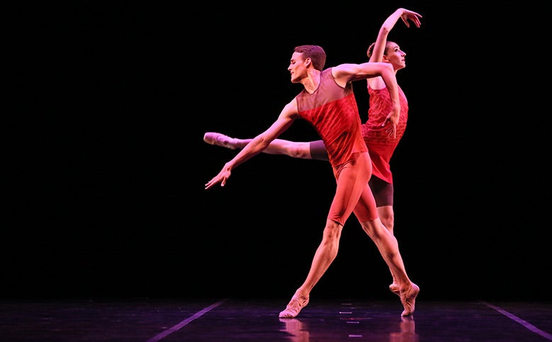 Two ballet dancers mid-movement on stage.