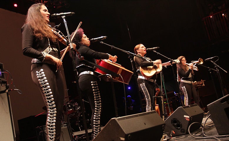 Female mariachi band performers on stage.