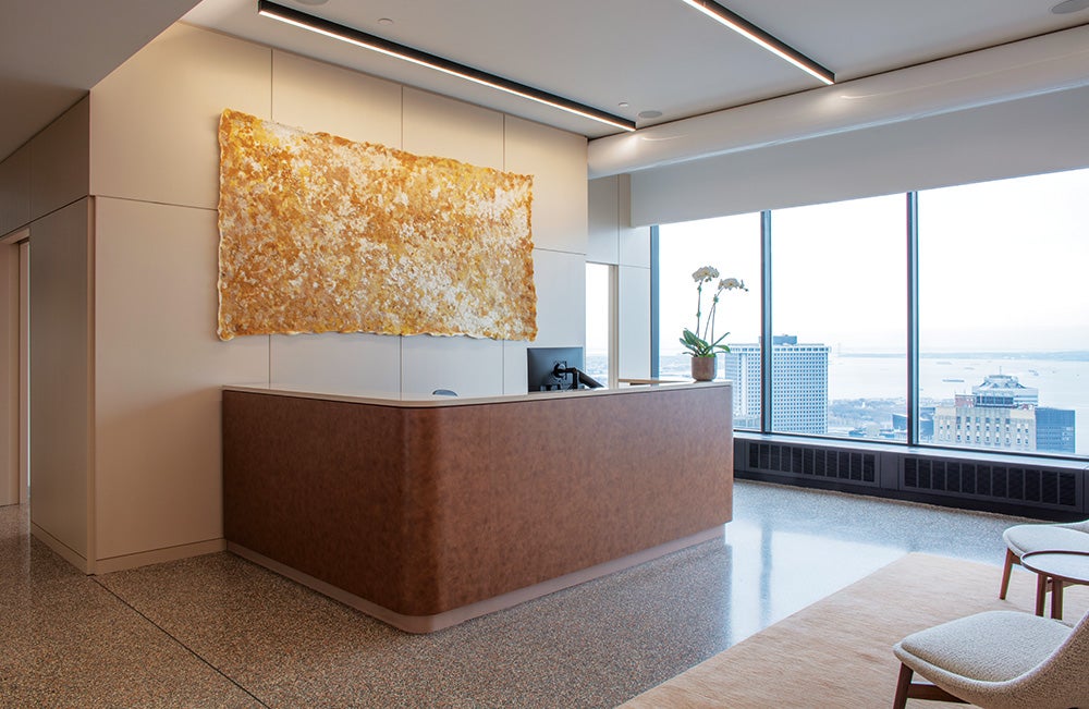 A reception desk with artwork hanging on wall behind in a NYC office.
