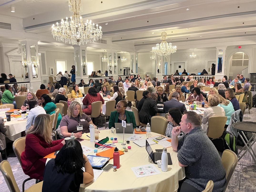 Attendees at the National Summer Learning Summit sit at conference tables.